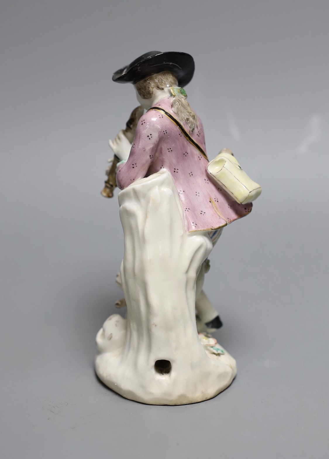 A Bow figure of a boy with dog playing the pipes, 25.5 cms high